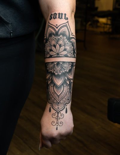 Forearm features a black ink mandala tattoo with the word "SOUL" above it.