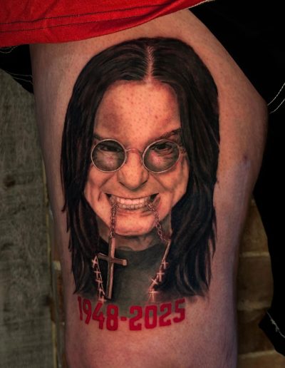 Ozzy Osbourne tattoo with 1948-2025 dates and cross necklace
