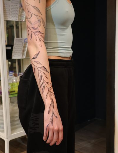 Woman with delicate vine tattoo on her arm