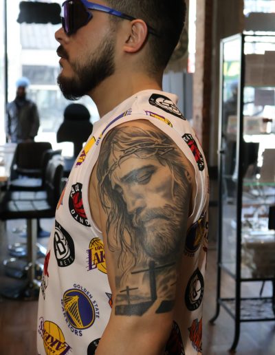 Man with Jesus tattoo on arm wearing NBA team logo shirt